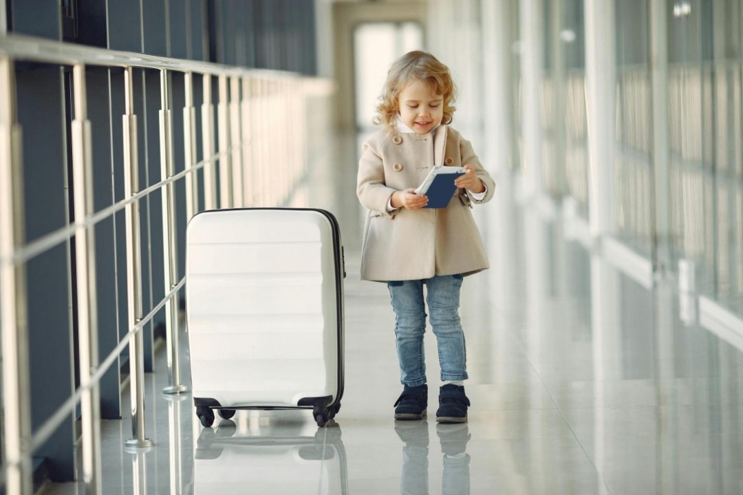 Little girl in an airport with a suitcase