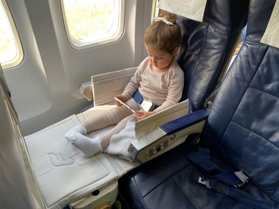 Little girl sitting in her plane seat  